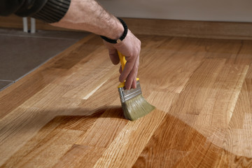 Home renovation parquet. Varnish paintbrush strokes on a wooden parquet