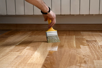 Home renovation parquet. Varnish paintbrush strokes on a wooden