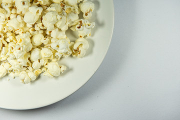 Popcorn in a plate on white background