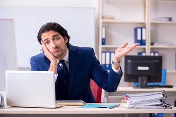 Obraz premium Young handsome businessman working in the office