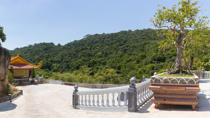 Buddhist temple and hill with tropical plants in the background