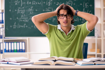 Handsome student in front of chalkboard with formulas 