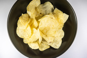 Potato chips in a plate on white background
