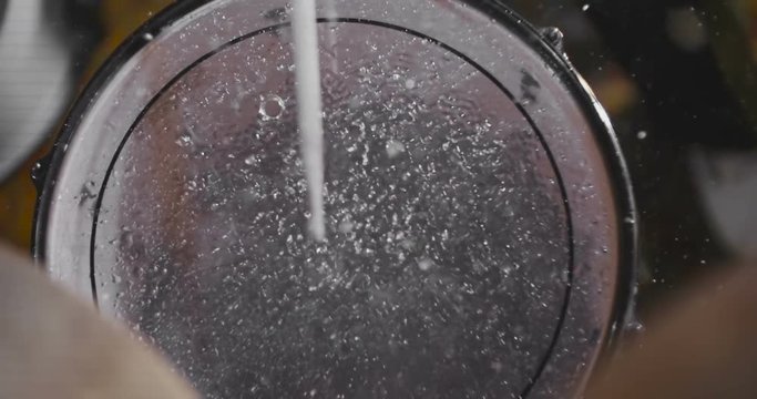 Top view of The drummer hit drum and water drops flying in all directions.