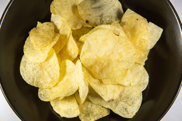 Potato chips in a plate on white background