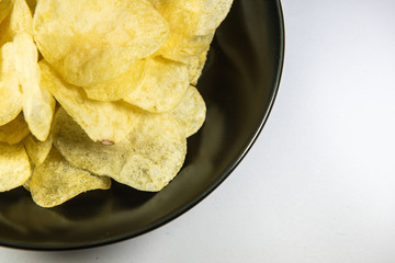 Potato chips in a plate on white background