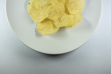 Potato chips in a plate on white background