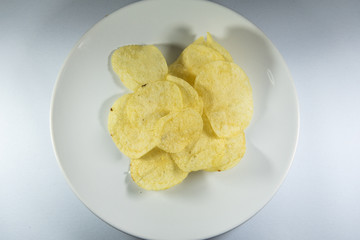Potato chips in a plate on white background
