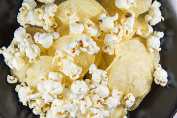 Potato chips and Popcorn in a plate on white background