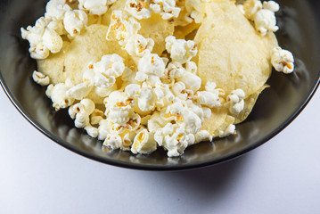 Potato chips and Popcorn in a plate on white background