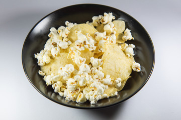 Potato chips and Popcorn in a plate on white background