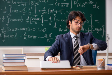 Young male math teacher in classroom 