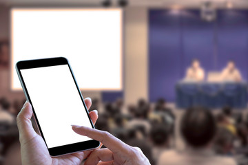 Mockup hand holding and showing mobile smart phone with blank white screen on meeting or conference...