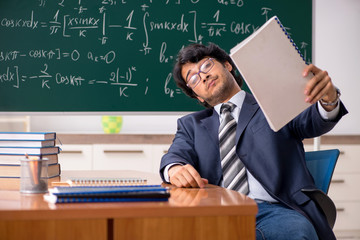 Young male math teacher in classroom 