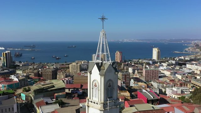 Aerial drone view of Iglesia de los Doce Apostoles old church and colourfully decorated houses on the hills of the historic port city of Valparaiso, Chile
