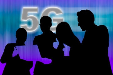 Two businesswomen and two businessmen looking at notebook computer and raising thumb up for 5G network result