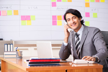 Young handsome employee working in the office