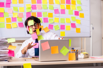 Young employee in conflicting priorities concept 