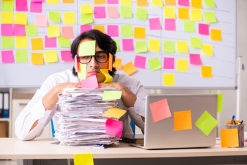Young employee in conflicting priorities concept 
