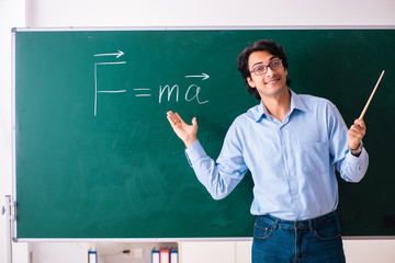 Young male physic standing in front of the green board