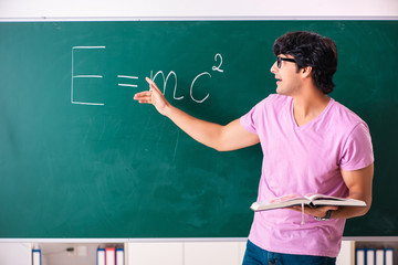 Young male physic standing in front of the green board