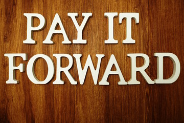 Pay it Forward  word alphabet letters on wooden background