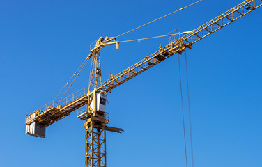 real high yellow crane tower isolate on blue sky background