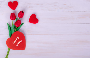 Women's day, Mother's day, Valentine's day concept Red tulips bouquet and a gift on white wooden background, top view and copy space for card and advertiser.