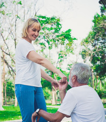 Fototapeta premium Happy old man kiss his wife hand at the park
