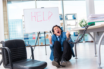 Chained male employee unhappy with excessive work 