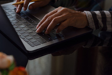 Closeup Woman hand typing on laptop computer keyboard.
