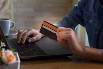 Woman using credit card,typing on laptop computer keyboard for online shopping and payment at home in free time. Business financial technology,e commerce,e banking,digital marketing concept.