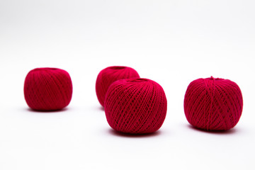 red balls of thread on white background