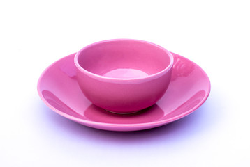 Empty pink cup of coffee with plate isolated on white background.