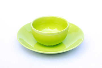 Empty green cup of coffee with plate isolated on white background.