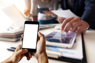 Hands holding smartphnoe working at the office.