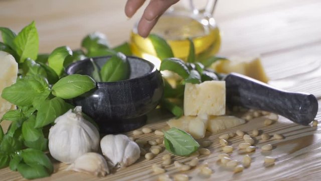 Preparation of pesto sauce from fresh basil, parmesan cheese, olive oil and garlic with a blender
