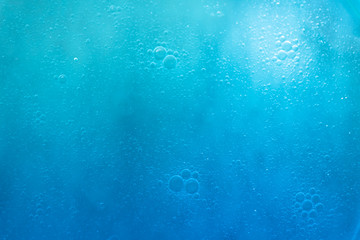 Fototapeta na wymiar Air bubbles in the water background.Abstract oxygen bubbles in the sea.Circle foamy air in the ocean.Water bubbles isolate on blue background