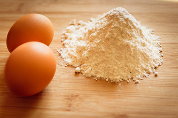 Fototapeta na wymiar eggs and flour on a wooden board