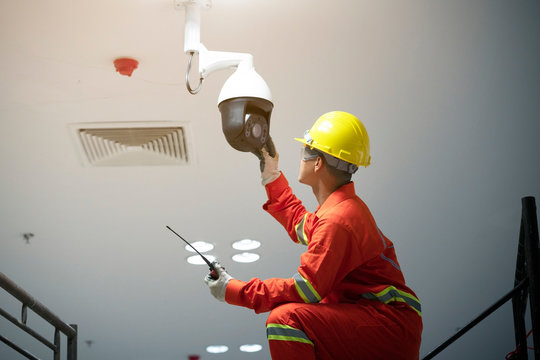 Technician fixing video surveillance camera or CCTV.