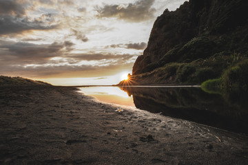 Beach sunset by cliffside