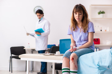 Leg injured young woman visiting male doctor 