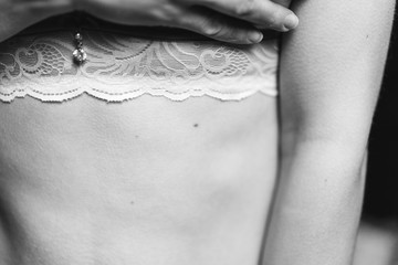  woman covers her chest in her bra with her hand, black and white photo, selective focus