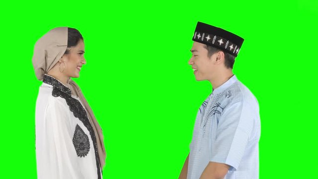 Young muslim couple giving a greeting hands gesture to each other and talking together in the studio