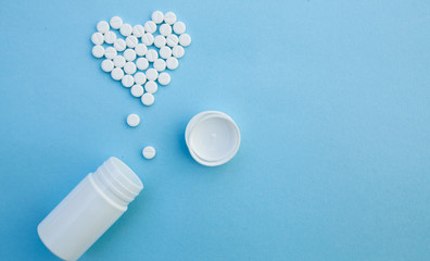 medicine, healthcare and pharmacy concept - pills and of drugs in shape of the heart