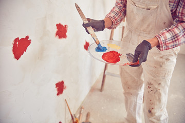 Working woman plastering / painting walls inside the house.