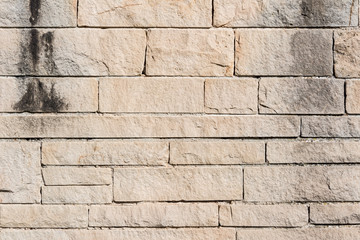 Hintergrund: verwitterte grau braune Steinmauer