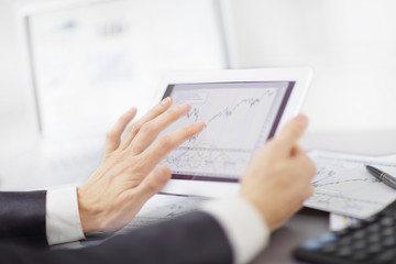 close up.the businessman makes a financial chart on a digital tablet