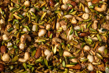 Turkish dessert with nuts and honey, pistachios, almonds and peanuts in soft focus at a food market