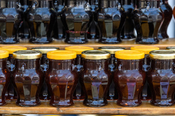 Close up of rows of jars with jam in display at a street food market